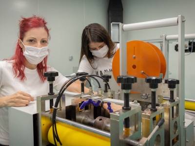 To kvinnelige arbeidere utforsker en ny maskin som lager N-95 kirurgiske munnbind for covid-19-beskyttelse i Tyrkia. Foto: ILO/Kivanc Ozvardar.